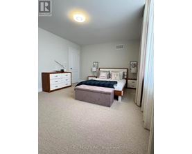 A bedroom with a bed, nightstand, and dresser.