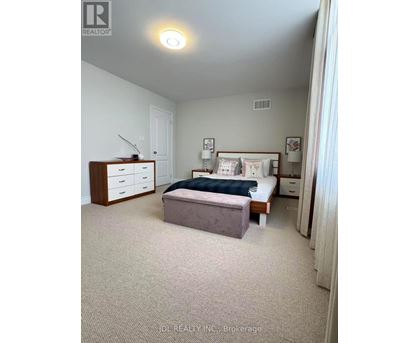 A bedroom with a bed, nightstand, and dresser.