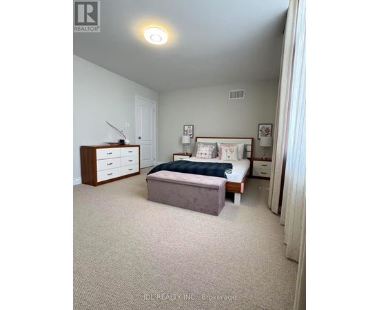 A bedroom with a bed, nightstand, and dresser.
