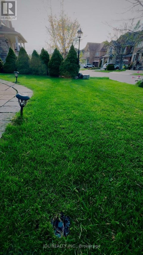 A grassy area with a bench and a sign that says "JDJ Realty INC, Brokerage".