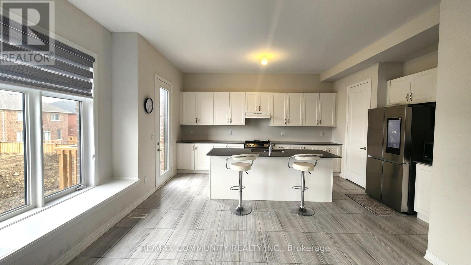 A modern kitchen with white cabinets and a bar area.