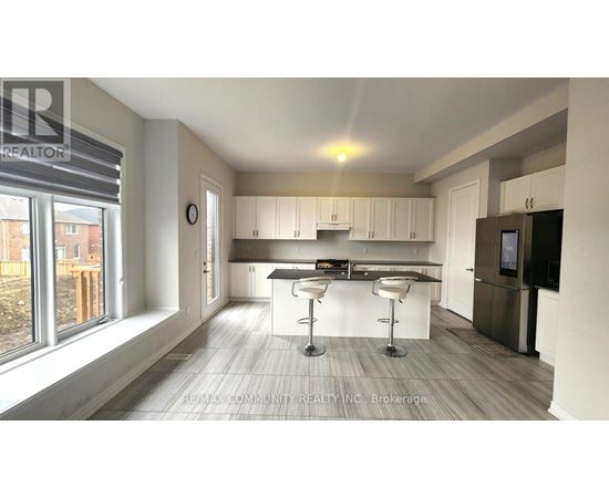A modern kitchen with white cabinets and a bar area.