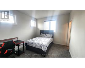 A bedroom with a bed, chair, and window.