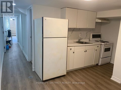 A kitchen with white cabinets and appliances in a real estate listing.