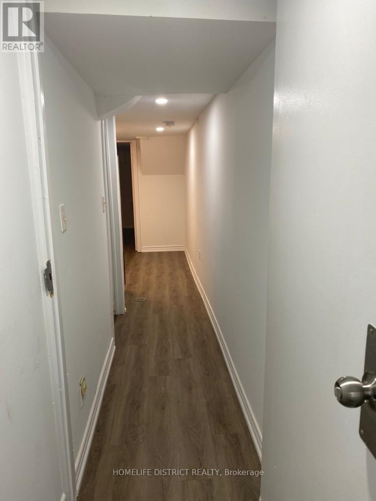 A hallway with a wooden floor and white walls.