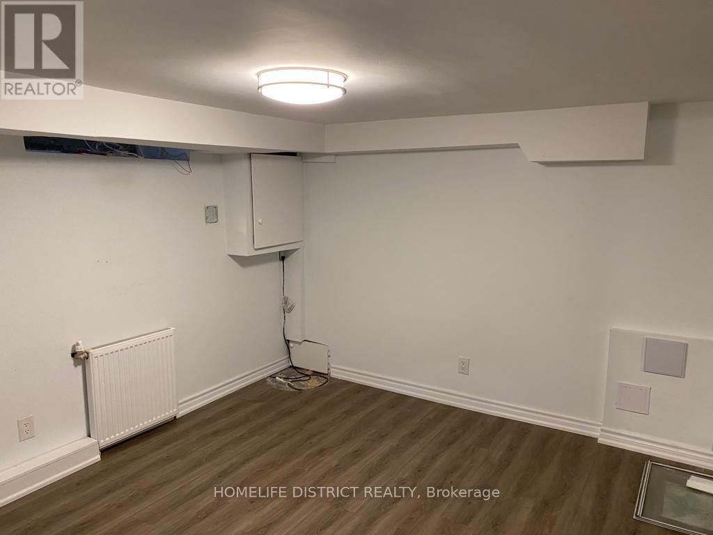 A room with a white wall and a radiator on the left side.
