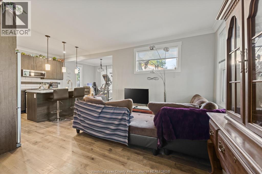 A well-lit, spacious bedroom with a large bed and a kitchen area in the background.