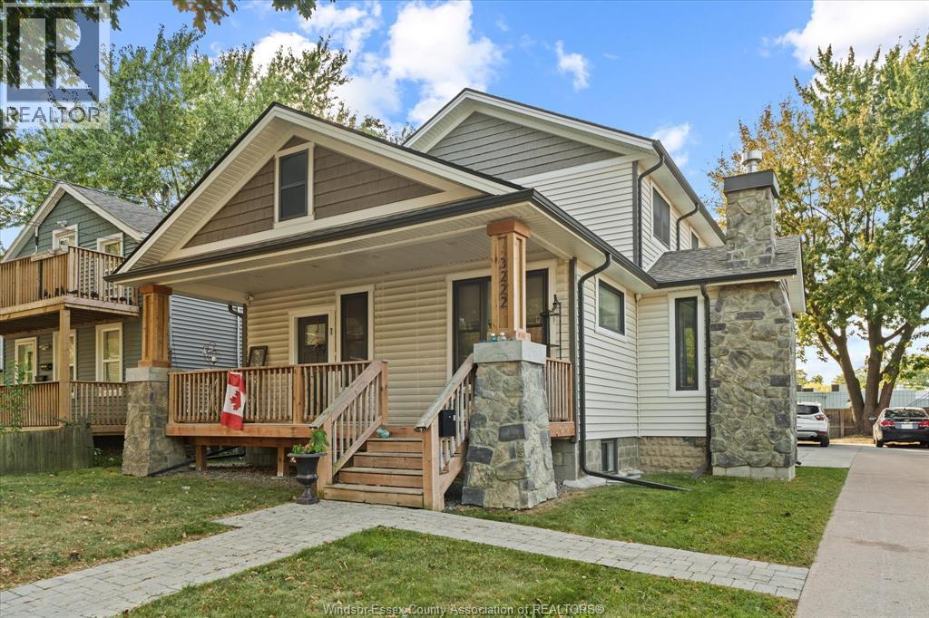 A house with a grey roof and a stone pillar in front.