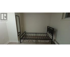 A bedroom with a bed and a sign that says "REALTY 21 INC, Brokerage".