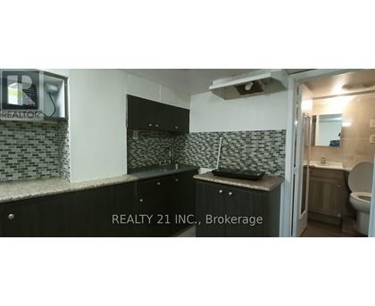 A bathroom with a black counter top and a mirror above it.