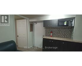 A small kitchen with a black counter top and a white door.