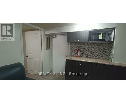 A small kitchen with a black counter top and a white door.