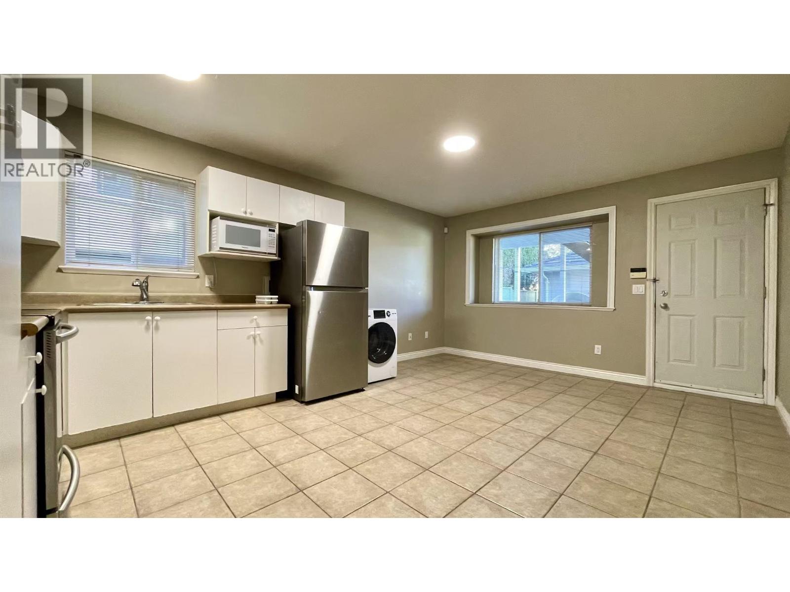 A kitchen with a refrigerator, microwave, and dishwasher.