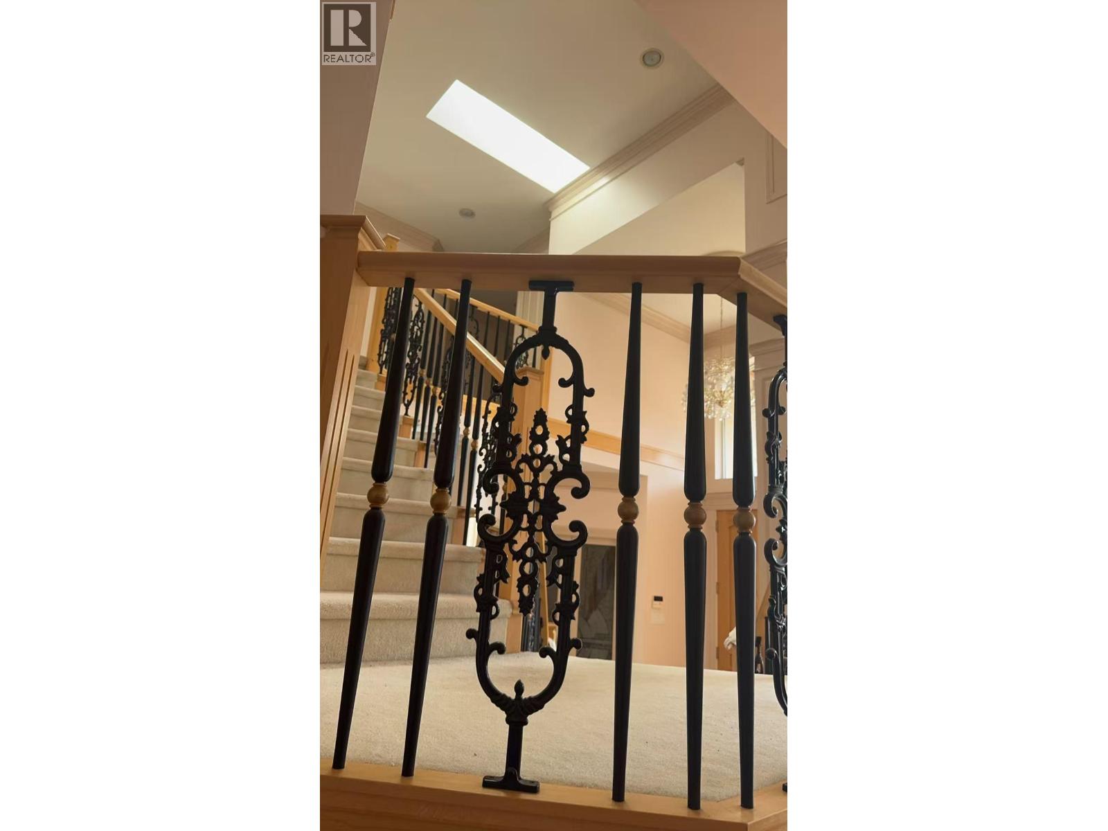 A staircase with a black wrought iron railing.
