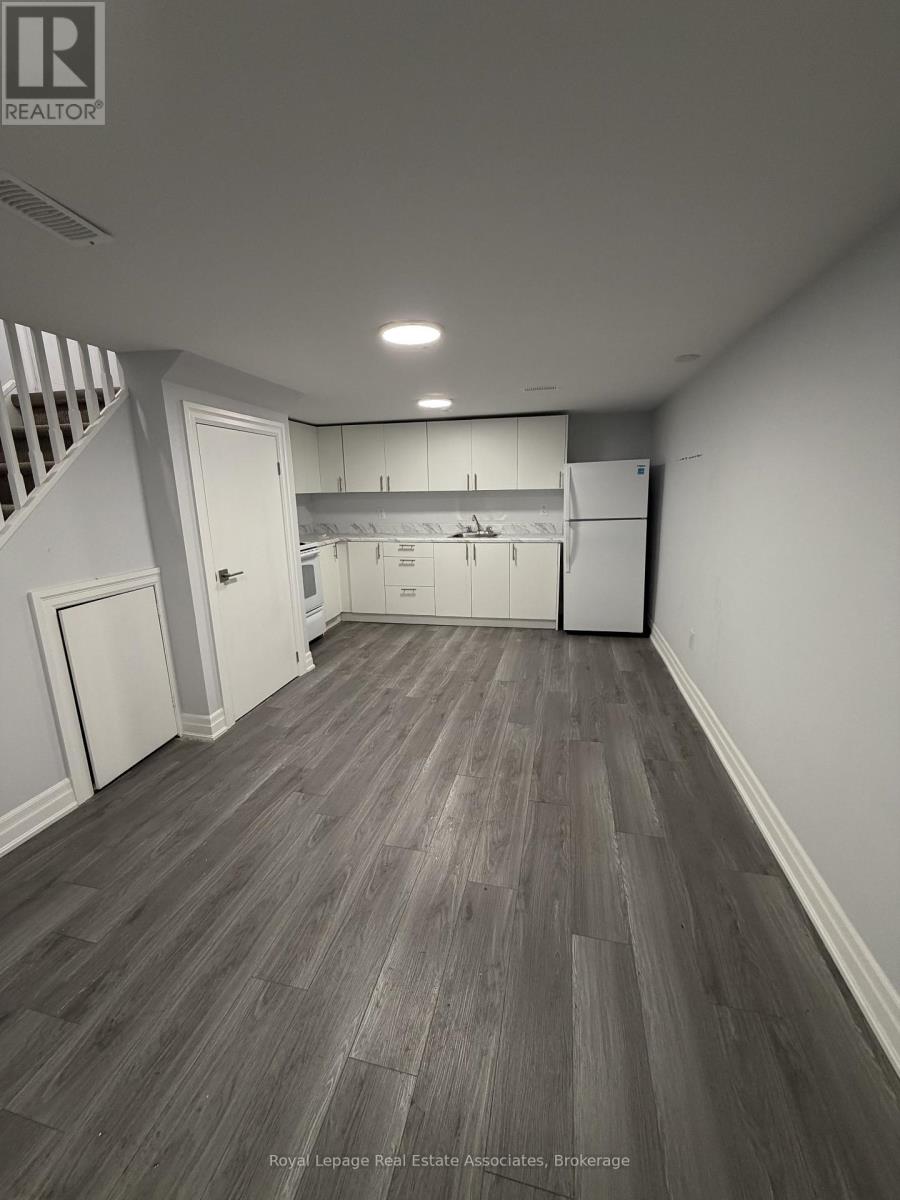 A spacious room with wooden flooring and white walls.