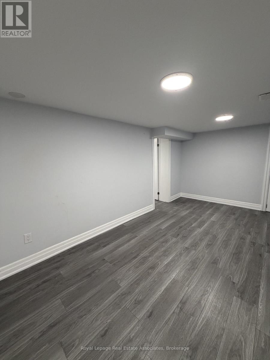 A room with wooden flooring and white walls.