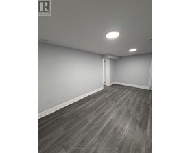 A room with wooden flooring and white walls.