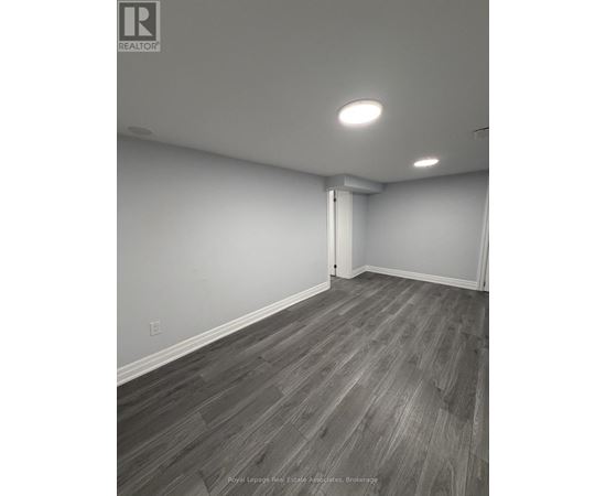 A room with wooden flooring and white walls.