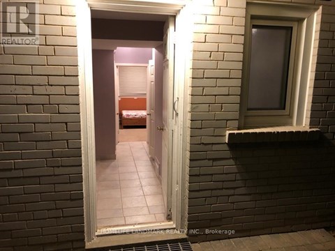 A bedroom is visible through a doorway in a brick wall.