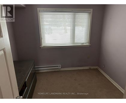 A room with a window and a radiator on the floor.