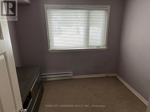 A room with a window and a radiator on the floor.