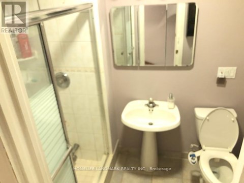 A white sink with a toilet and a shower in a bathroom.