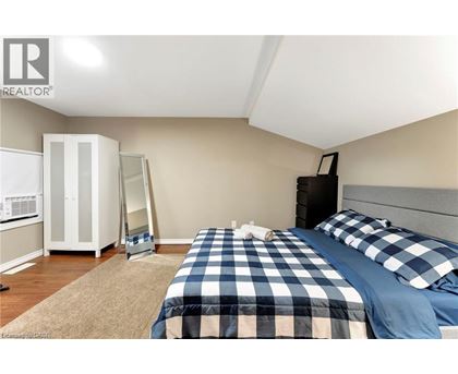 A bedroom with a bed, dresser, and wardrobe.