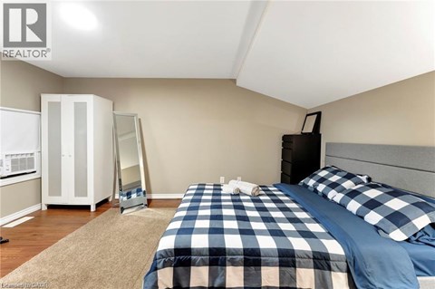 A bedroom with a bed, dresser, and wardrobe.