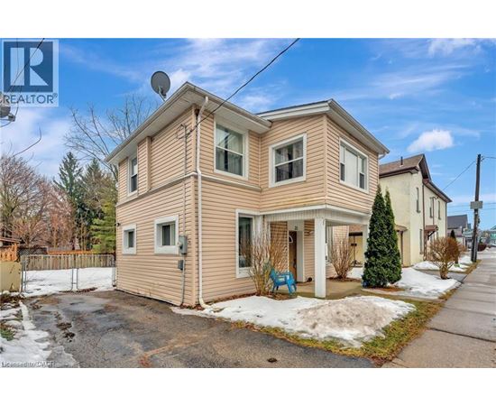 A two-story house with a beige siding and a satellite dish on the roof.