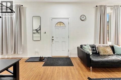 A living room with a black couch and a white door.
