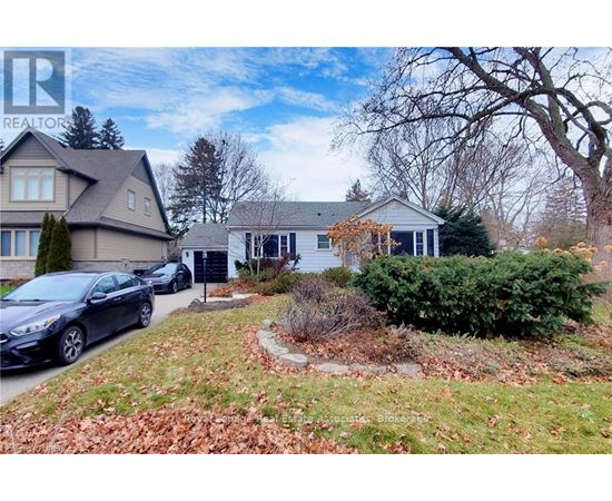 A realtor logo is superimposed on a photo of a house with a car parked in front.