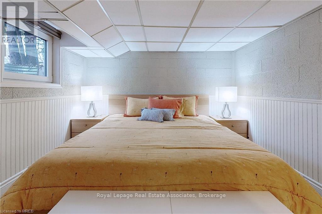 A bedroom with a bed in the middle and two lamps on the side.