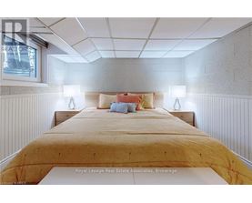 A bedroom with a bed in the middle and two lamps on the side.