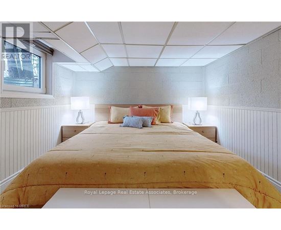 A bedroom with a bed in the middle and two lamps on the side.