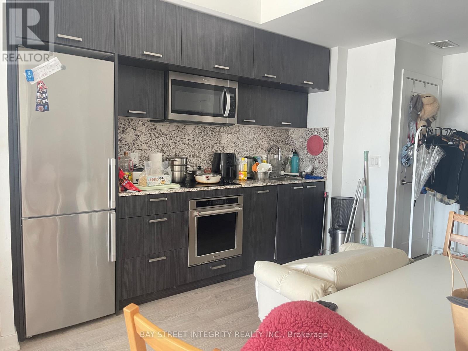 A kitchen with a refrigerator, oven, microwave, and cabinets.