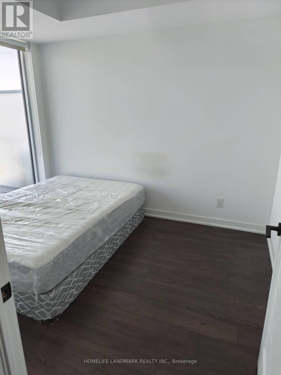 A bedroom with a bed and wooden floors.