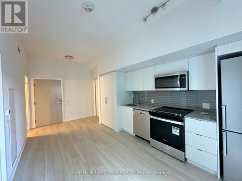 A kitchen with white cabinets and a black stove top oven.