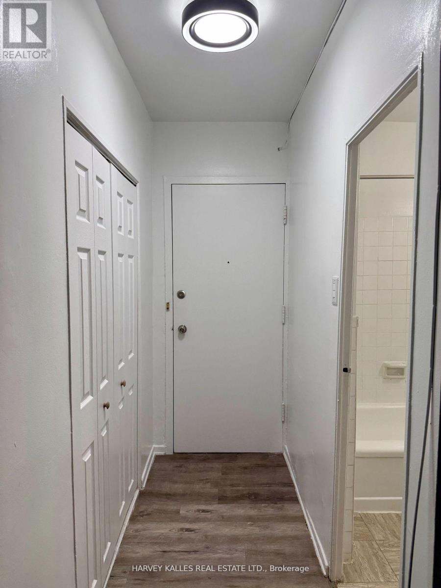 A hallway with white doors and a wooden floor.