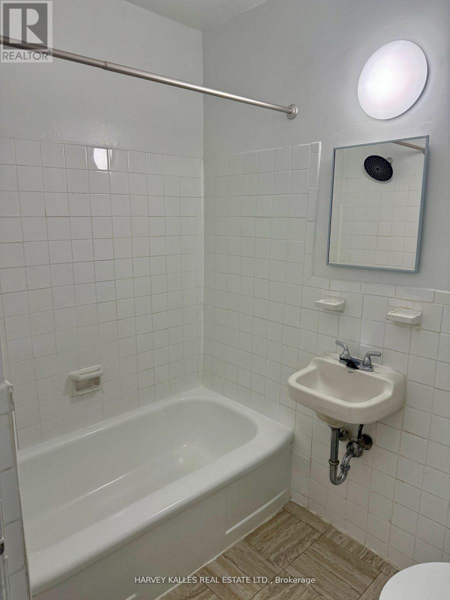 A white bathroom with a tub, sink and toilet.