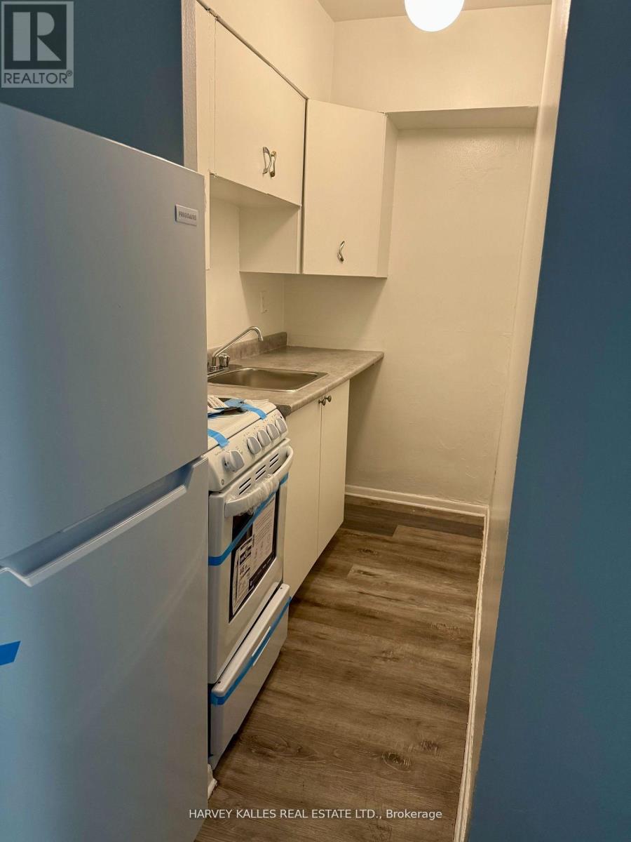 A small kitchen with a white fridge and a white oven.
