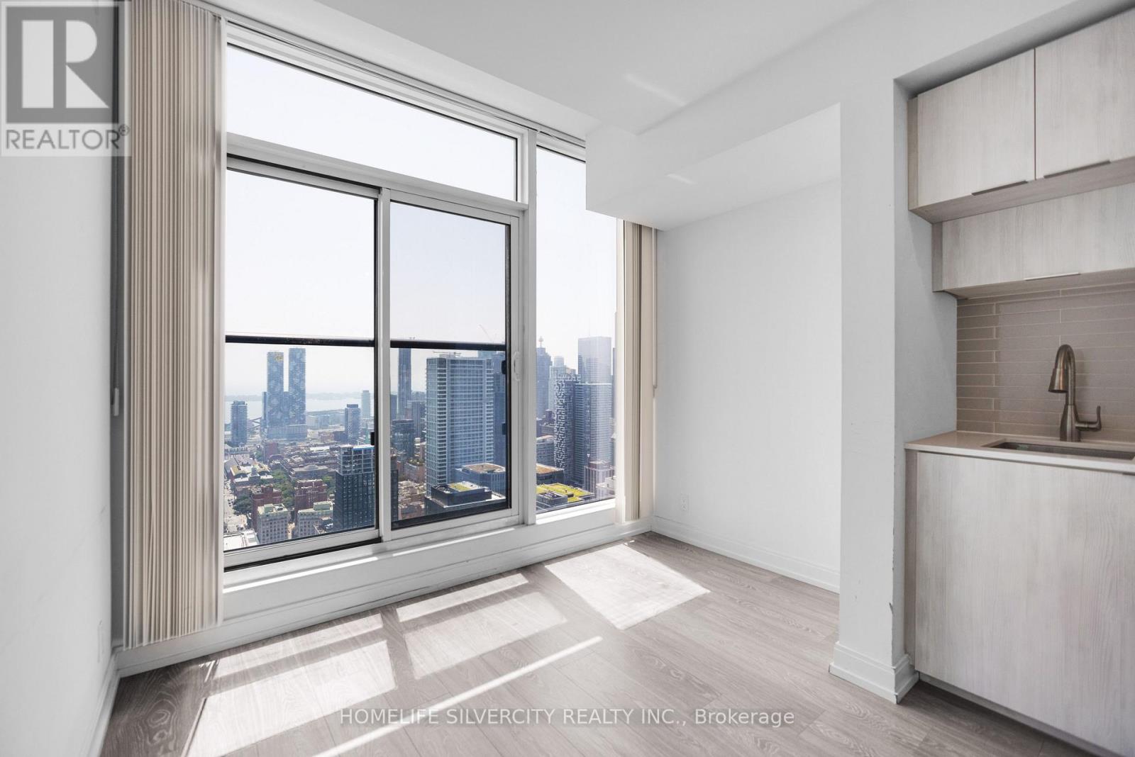 A well-lit, spacious room with a view of the city skyline.