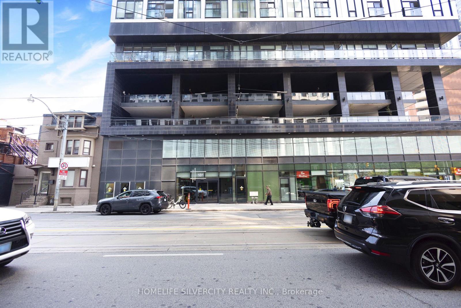 A building with a glass facade and a parking garage in front of it.