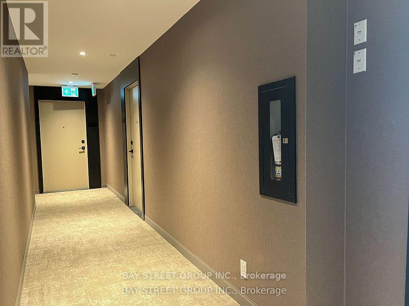 A hallway with a brokerage sign on the wall.