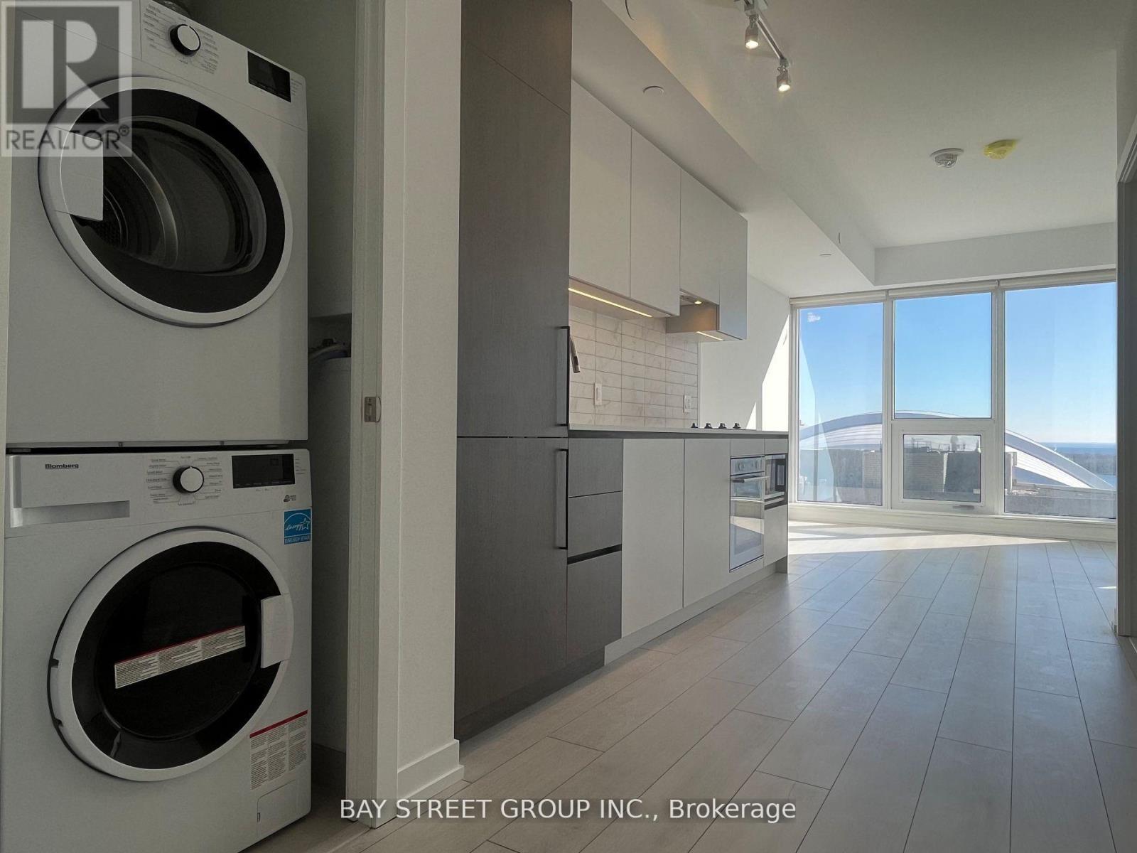 A modern kitchen with a washing machine in the foreground.