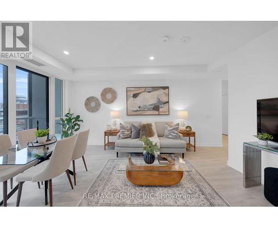 A modern living room with a glass table and a grey sofa.