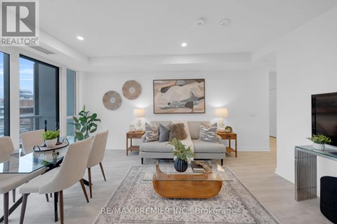 A modern living room with a glass table and a grey sofa.