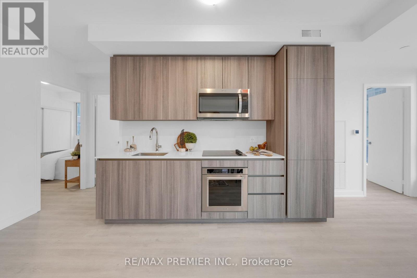 A modern kitchen with a wooden cabinet and a microwave above the oven.