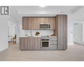 A modern kitchen with a wooden cabinet and a microwave above the oven.