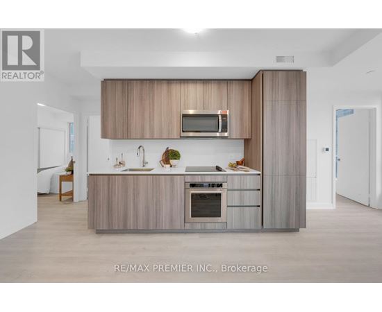 A modern kitchen with a wooden cabinet and a microwave above the oven.