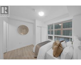 A bedroom with a bed and a window overlooking a building.
